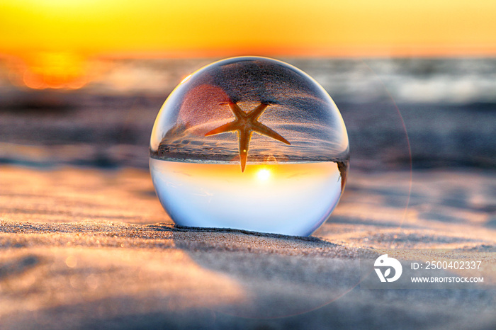 Beautiful sunset on the beach in Slowinski National Park near Leba, Poland. View of a starfish throu