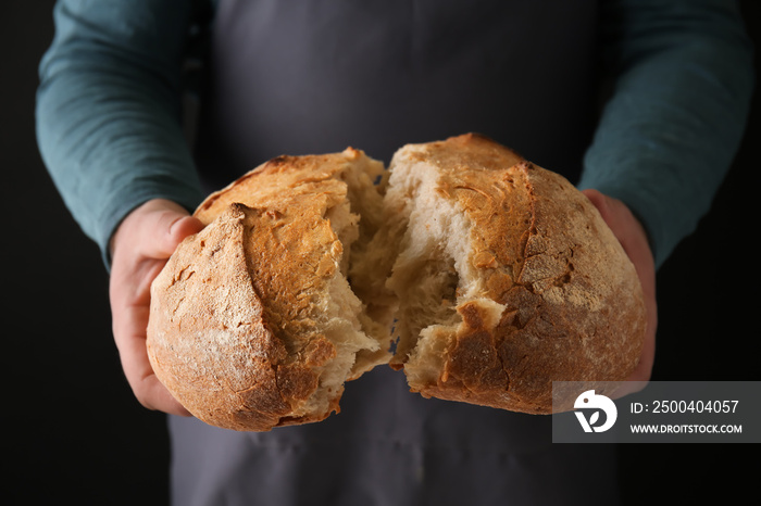 Man with loaf of fresh bread, closeup