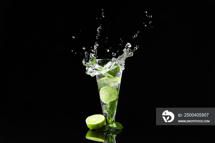 Glass of fresh mojito with splashes on dark background