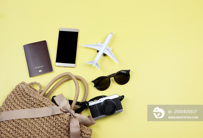 护照、手机、飞机模型、太阳镜和相机放在黄色编织袋中