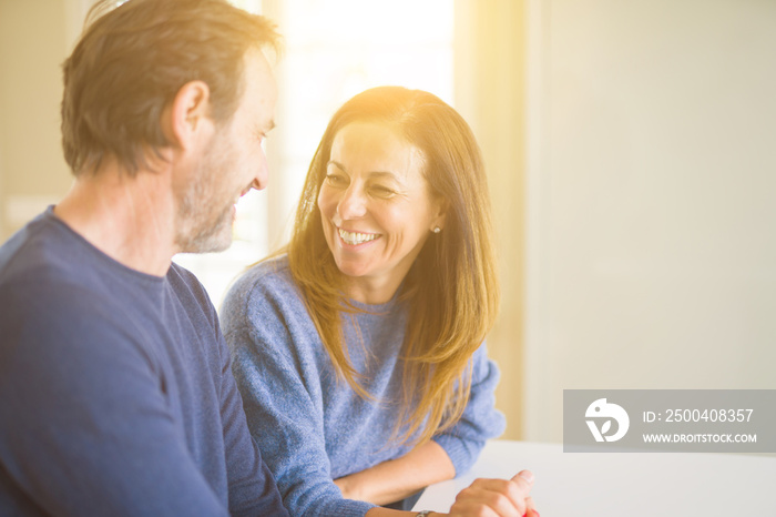 Romantic middle age couple sitting together at home