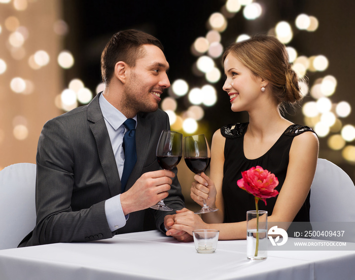 dating, celebration and valentines day concept - smiling young couple clinking glasses of non-alcoho