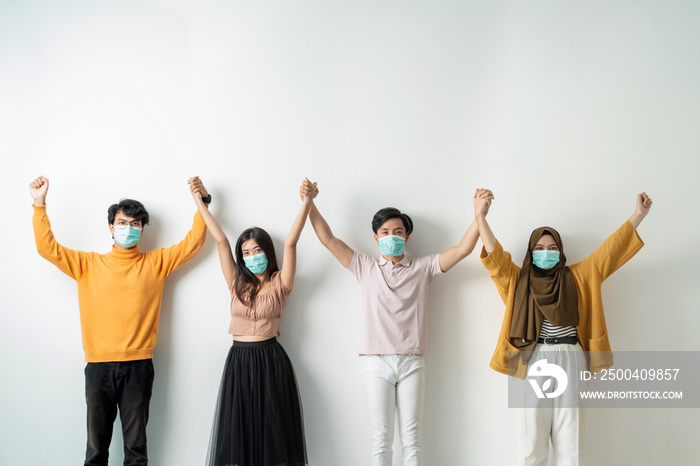 people with face masks hold hand supporting each other. fights against the virus