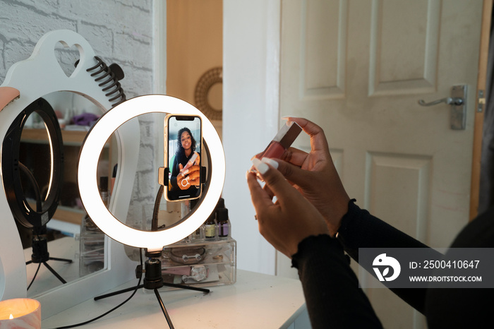 Teenage girl filming makeup video at home