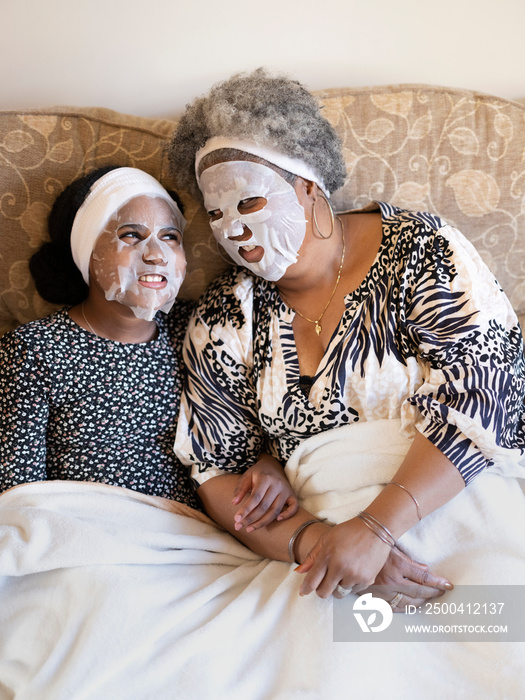 Mother and daughter relaxing with face masks
