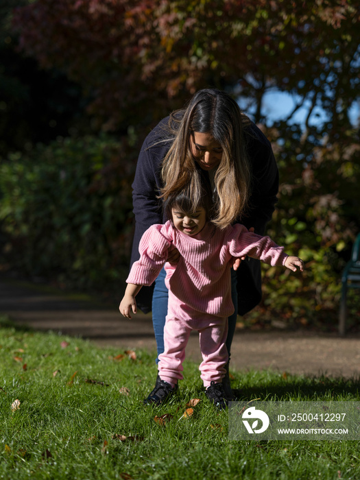 Mother and daughter with Down syndrome walking in park