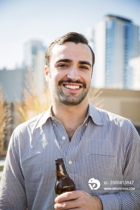 Portrait of man holding beer bottle