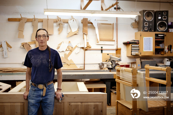 Portrait of carpenter standing in woodshop