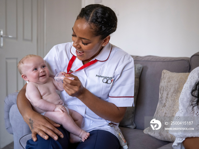 Nurse taking care of baby girl (2-5�months)