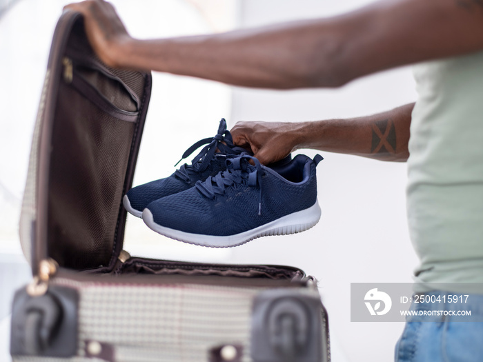 Close-up�of person putting sport shoes into suitcase