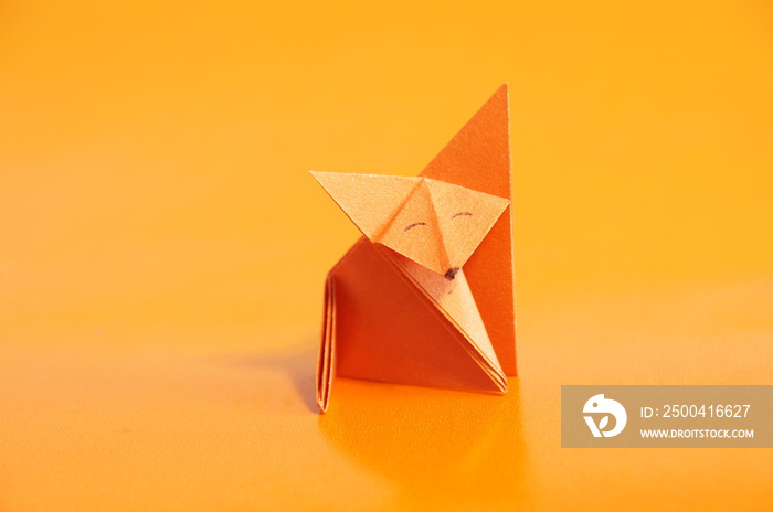 Paper origami fox isolated on a colorful background