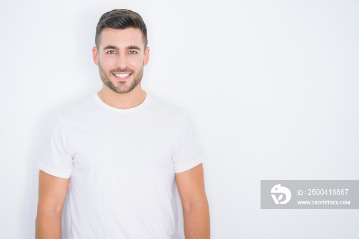 Young handsome man smiling happy wearing casual white t-shirt over white isolated background