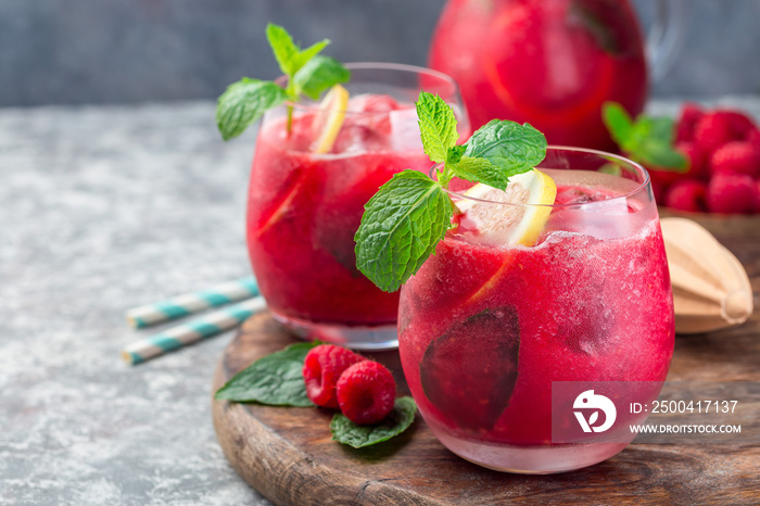 Refreshing raspberry, lemon and mint lemonade with sparkling water in  glass, horizontal, copy space