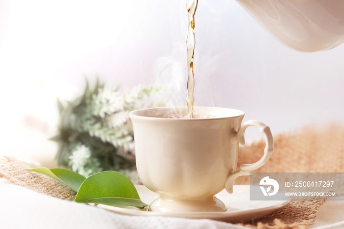 Close up pouring hot jasmine tea in a white tea cup ,  Tea ceremony time concept