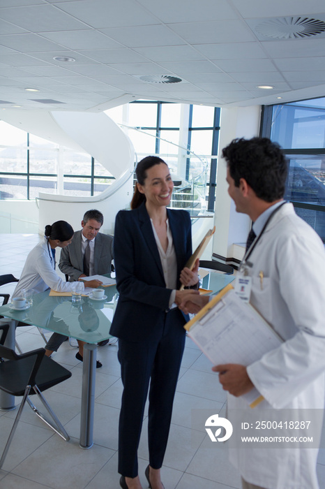 Hospital administrator shaking hands with doctor in meeting