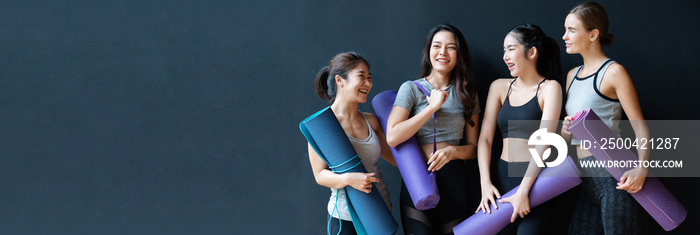 一群来自不同国籍的女性站在一起谈论瑜伽，设备就是垫子。