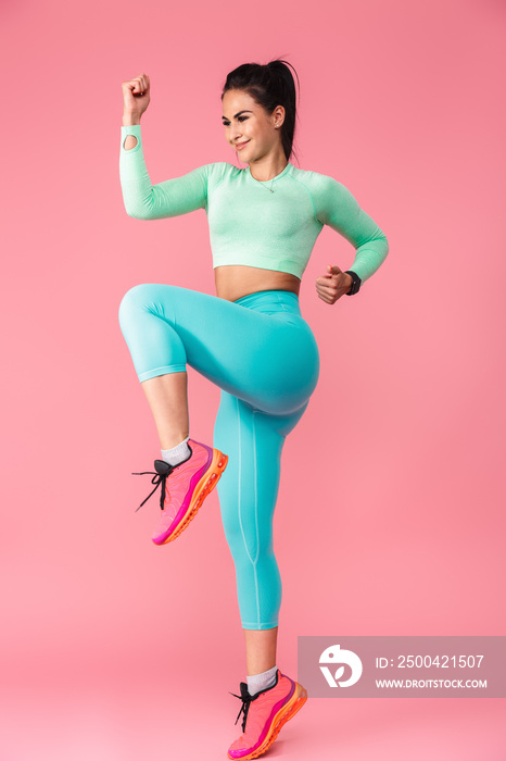 Young sports fitness woman isolated over pink wall background make exercises.