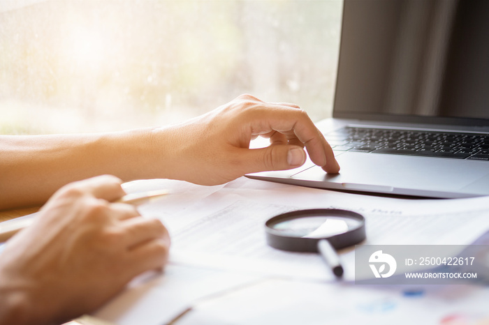 man looking through a magnifying glass to documents. Business assessment and audit. Magnifying glass