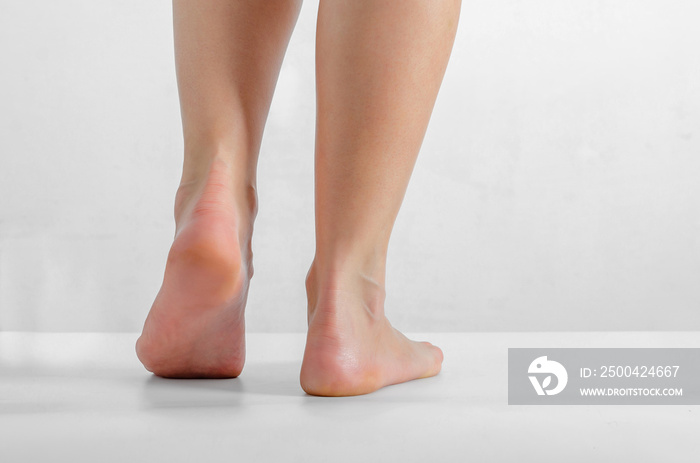 Female feet, feet stand on a white background, Smooth skin, foot care.