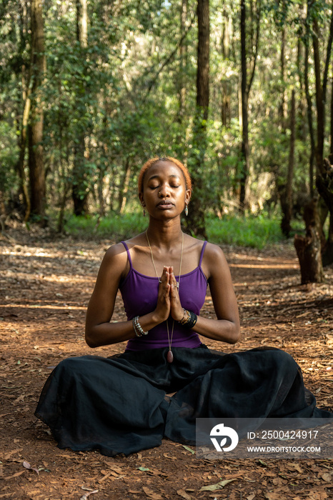 young woman sitting on the ground in the lotus pose