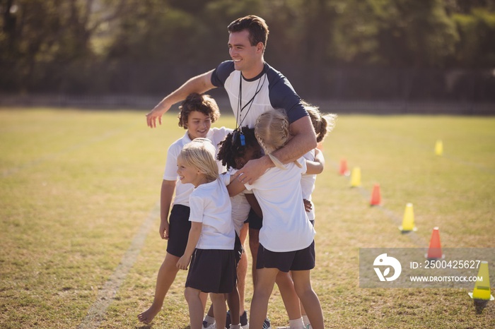 Schoolgirls embracing coach during competition