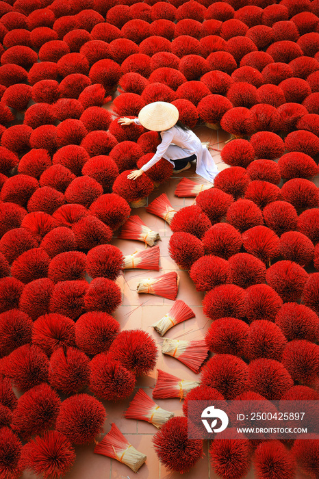 Incense sticks drying outdoor with Vietnamese woman wearing conical hat in Hanoi, Vietnam