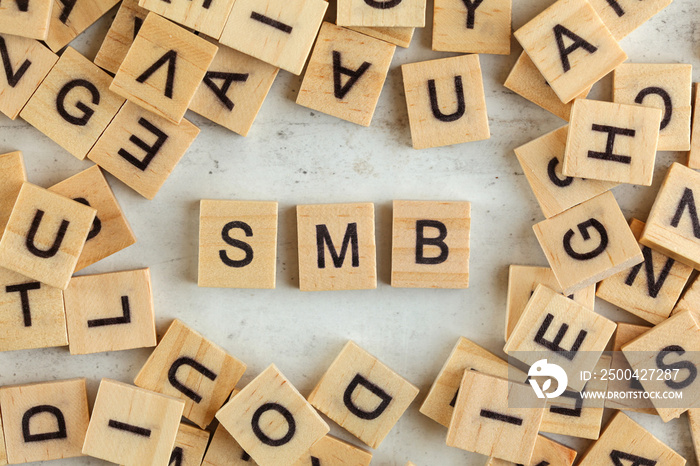 Top down view, pile of square wooden blocks with letters SMB (stands for Small to Medium Business ) 