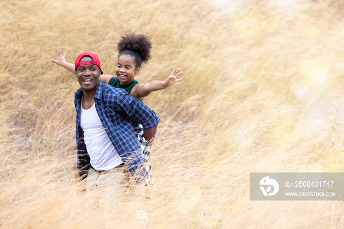 美丽快乐的非裔美国人父女在干草或干草上快乐微笑。非洲人