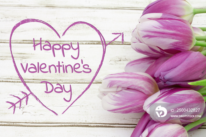 Happy Valentines Day greeting with tulips on weathered wood