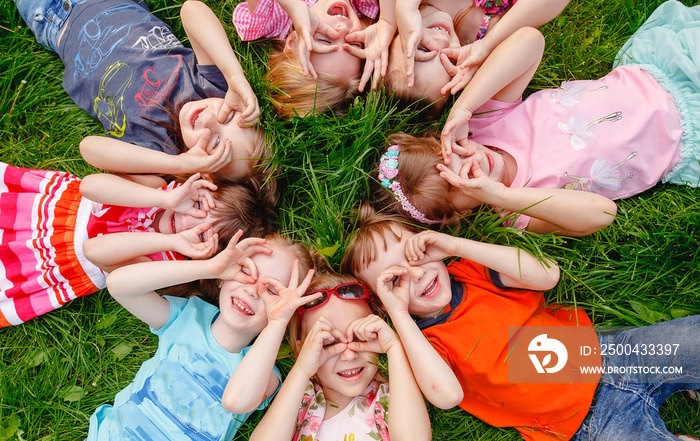 a group of children playing and running in the park on a green gozon.