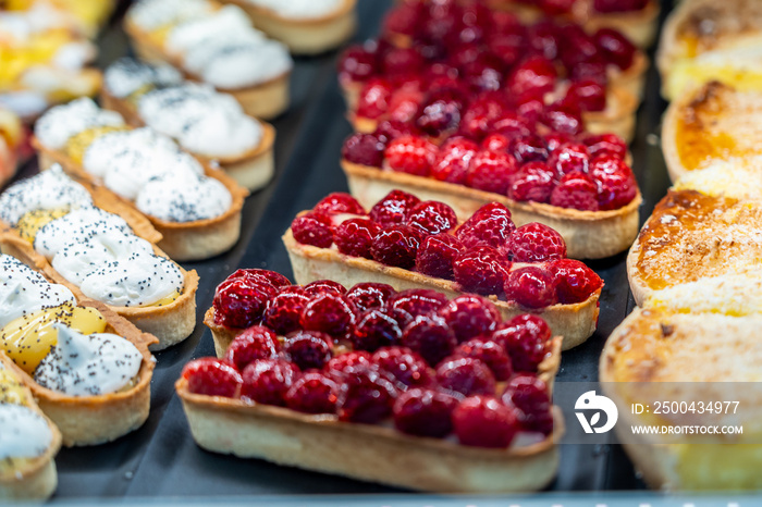 Colorful raspberry cream cheese tart and fruit tart in bakery