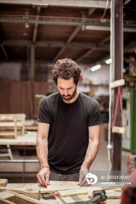 Male carpenter working at workbench in workshop