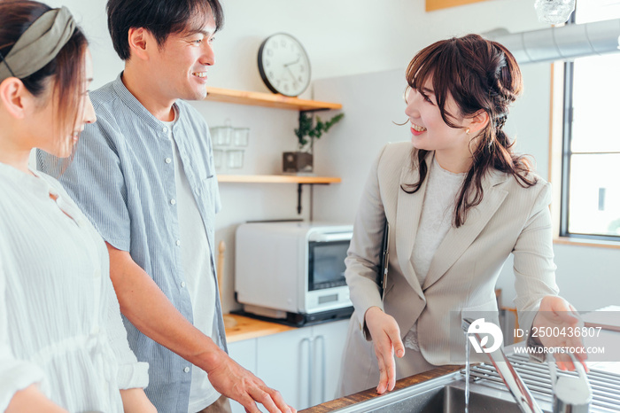 キッチンの設備を説明する女性（水道）