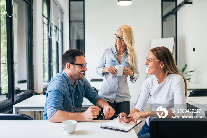 Three casual business people laughing and having fun at training seminar.