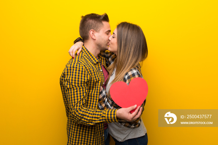 Couple in valentine day holding a heart symbol and kissing