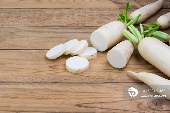 white radish and sliced ​​radishes placed on a simple wooden table with copy space - top view