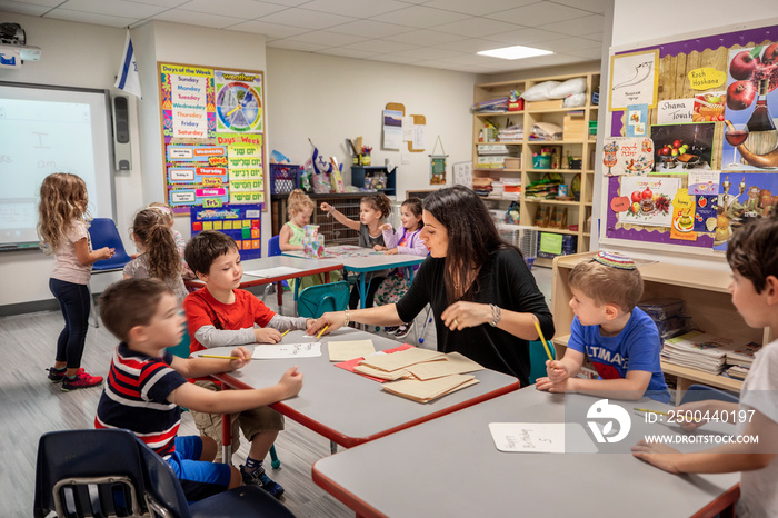 Teacher helping children with their classwork