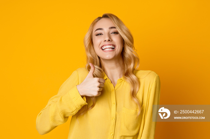 Overjoyed Girl Showing Thumb Up and Widely Smiling