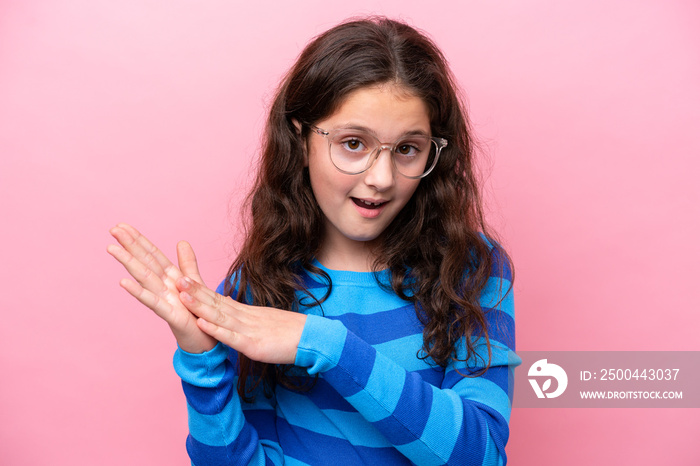 Little girl isolated on pink background With glasses and applauding