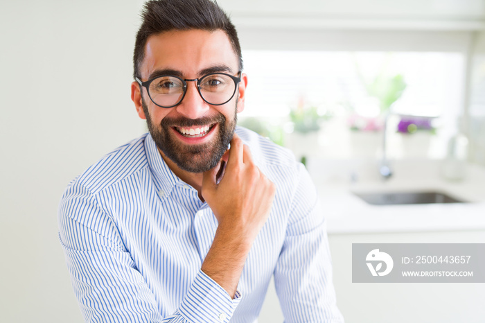 Handsome business man wearing glasses and smiling cheerful with confident smile on face