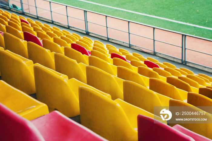 Empty stadium. Rows of yellow and red seats in stadium. Concept of empty stadium without spectators,