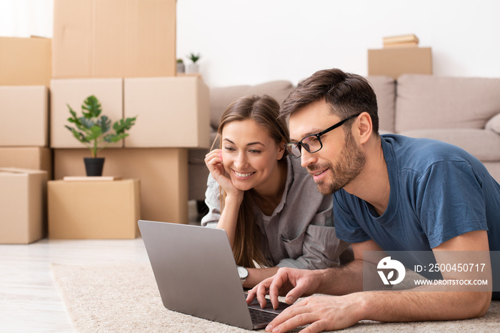 Happy couple searching for ideas during repair and looking at laptop