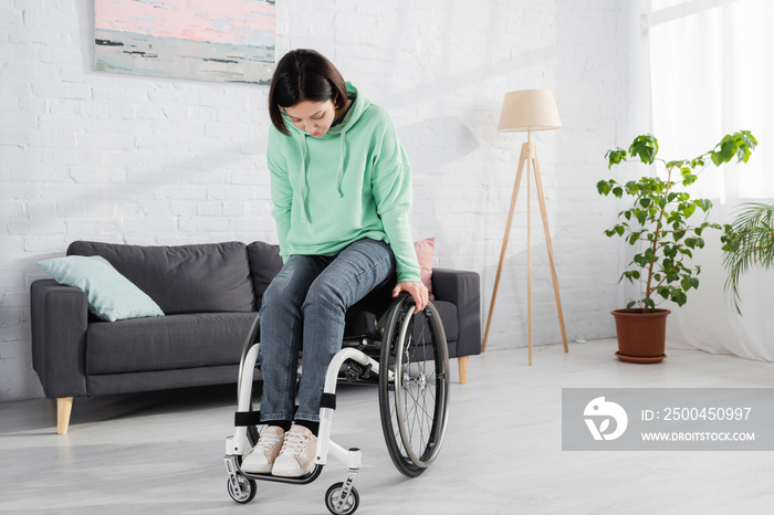 Pretty woman in wheelchair exercising at home