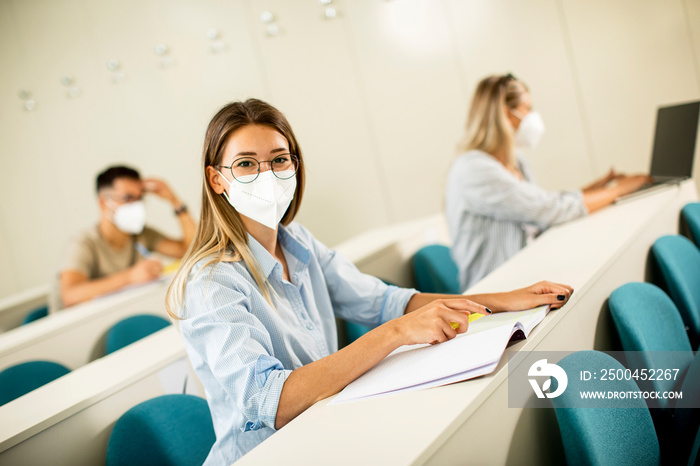 Female student wearing face protective medical mask for virus protection at lecture hall