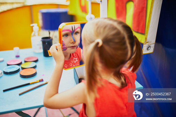 Artist painting little preschooler girl like butterfly. Creative activities for kids