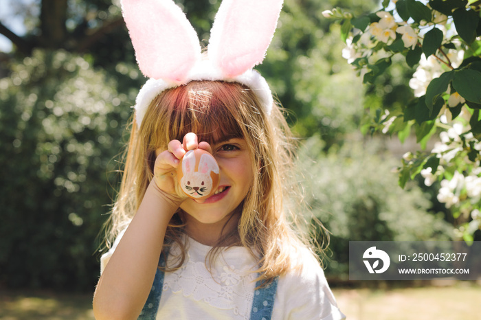 Portrait of a little girl showing a painted easter egg