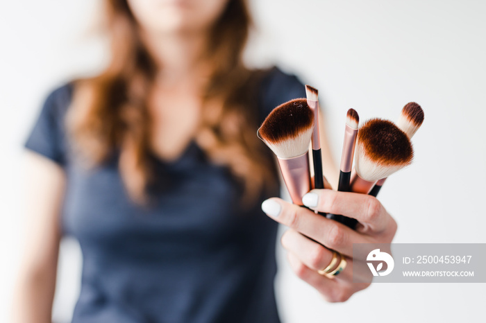 girl holding make-up brushes in front of the camera showing the product, beauty bloggers and influen