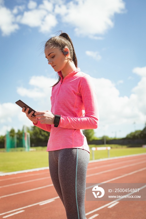 Woman using mobile phone on a race track