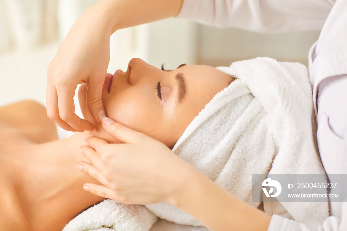 Facial massage to a beautiful girl in a beauty clinic.