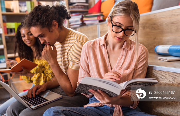 Young female student study in the library reading book.